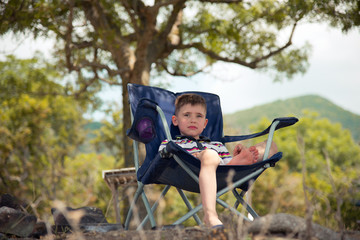 Child resting in a chair at the seaside