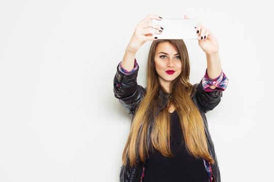 Modern millennial teenage girl in black taking a selfie on cellphone