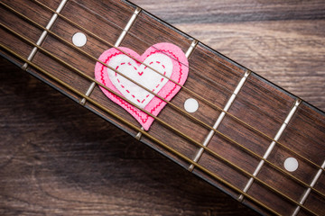 Fiber heart under guitar strings concept of music love.