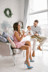 Young mother holding cookies with young baby and father