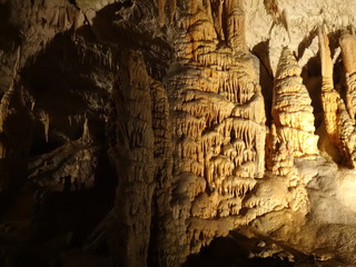 Fototapeta na wymiar Пещера со сталактитами и сталагмитами в желтом освещении