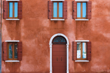 Fototapeta na wymiar Colorful facades with doors and windows in Burano, Italy.