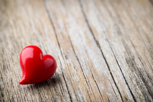 Red heart-shaped on a wooden background.