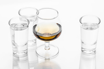Vodka shot glass and cognac glass isolated on white.