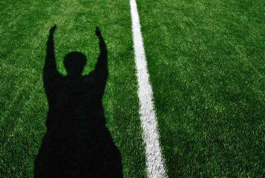 Shadow Of American Football Referee Signaling Touchdown