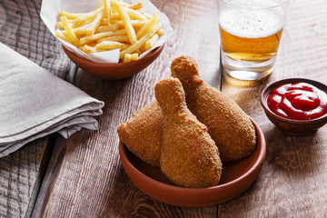 Fototapeta na wymiar fried chicken leg in breadcrumbs and french fries