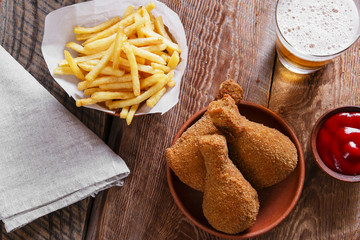 fried chicken leg in breadcrumbs and french fries