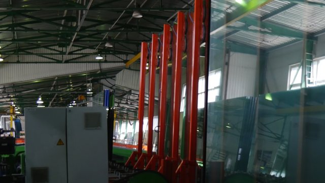 Machine is Laying Down Large Sheets of Glass, Arms are Laying the Glass, Levers, Glass Factory, Production Line of Glass