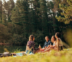 Group of teenagers having a picnic on the lake
