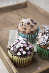 Photo of tasty cupcakes with chocolate over wooden table