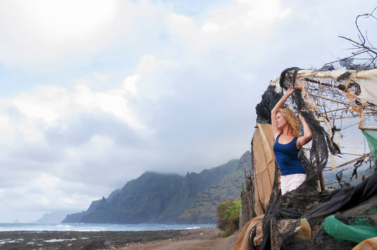 Beautiful young woman looking at the ocean stormy coast