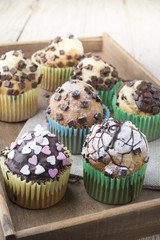 Photo of tasty cupcakes with chocolate over wooden table