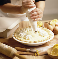 Piping cream onto Lemon meringue pie