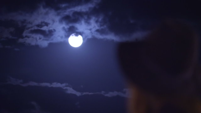 Young woman looking back and look at the full moon at night