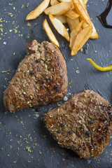 Grilled T-bone steak seasoned with spices and fresh herbs served