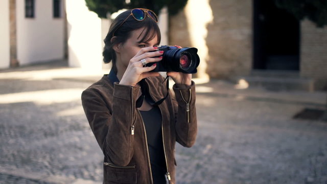 Woman taking photo of ancient city in Andalusia in Spain
