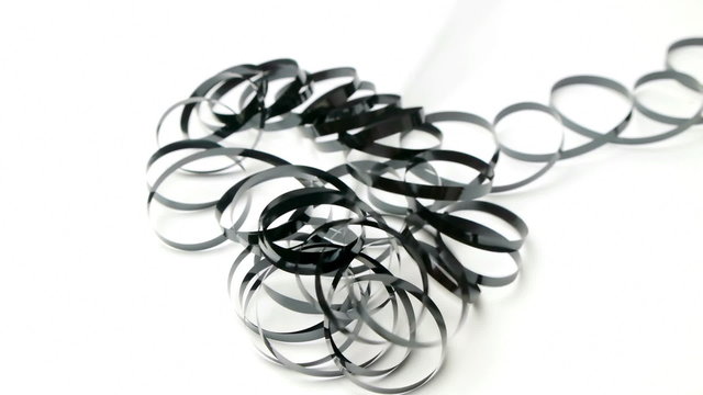 Audio Tape Loops Entangled over White Background