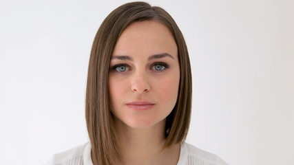 Serious woman looking at camera, takes a look to the right and looks at camera again - Powered by Adobe