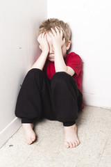 Neglected lonely child leaning at the wall