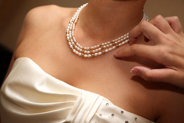 bridesmaid corrects the decoration of the neck of the bride