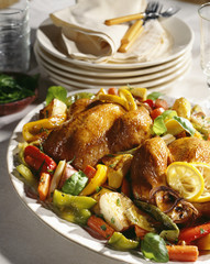 Roast chicken with vegetables on serving tray.