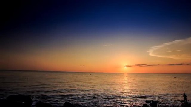 Silhouette of Fishman with Rod on Beach at Sunset