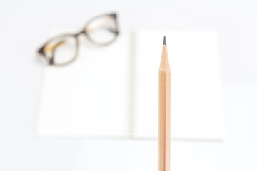 Pencil with notebook and eye glasses