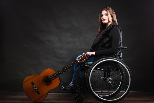 Woman invalid girl on wheelchair with guitar