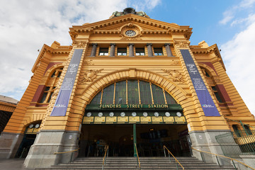 Main entrance of Flinders Street Station in Melbourne with clocks showing departure times for trains. No people present in the photograph.