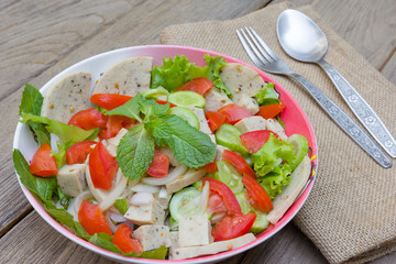 Thai cuisine spicy pork salad on wood background or Yum Moo Yor