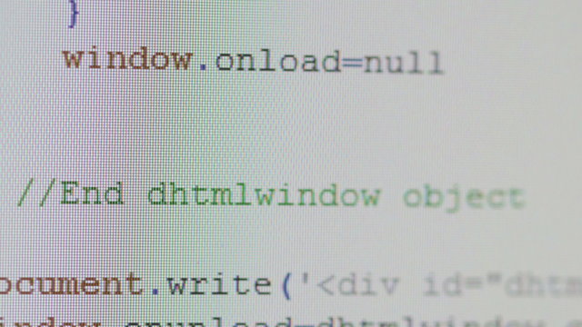 Close-up of computer code running on desktop pc monitor