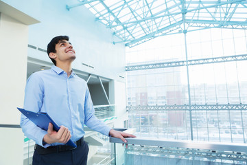 Fototapeta premium Businessman leaning on balcony railings