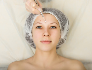 Beautician examining the face of a young female client at spa salon. face cleaning, Una cuchara. Professional consultation