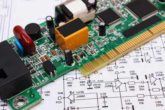 Printed circuit board lying on diagram of electronics, technology