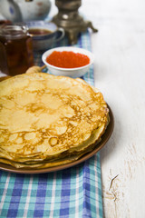 Pancakes with red caviar on a table.