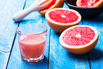 Grapefruit juice and fresh fruits on wooden table