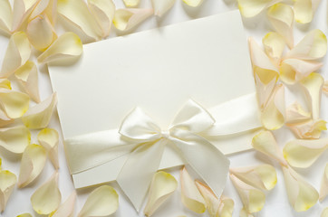 card with ribbon and rose petals