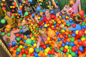 Fototapeta na wymiar children and parents have fun with colored balls