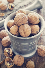Metal Mortar and walnuts on a wooden background
