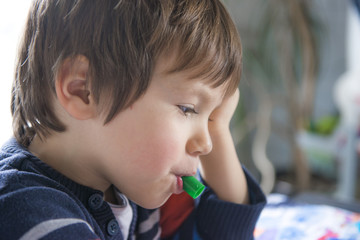 enfant avec un objet dans la bouche