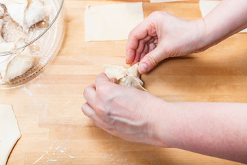woman prepares dumplings from rolled dough