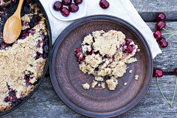 Homemade Cherry crumble and cherries on an old wooden table background.Selective focus.
