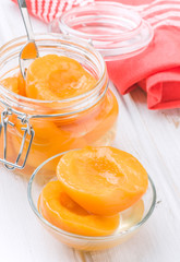 means peaches in syrup in glass bowl, on wooden