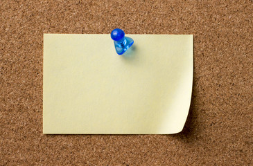 Blank adhesive label pinned on bulletin board