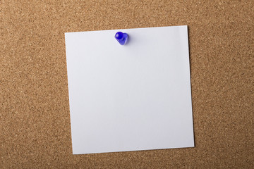 Blank adhesive label pinned on bulletin board