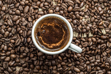 Cup of coffee and coffee beans background, selective focus.