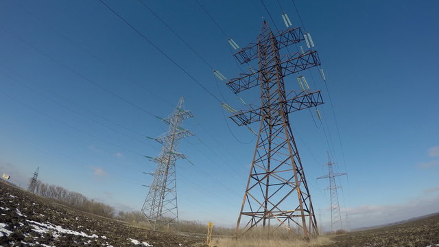 Electric high voltage pylon against sky. Time lapse.