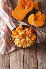 Dietary food: rice with pumpkin on the table. vertical
