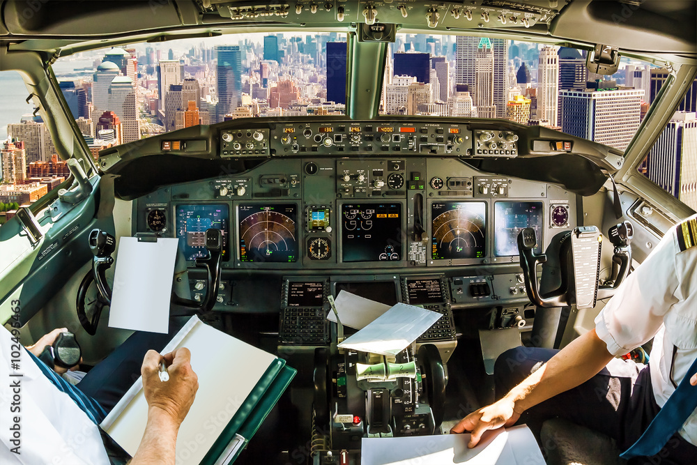 Wall mural cockpit and board of an airplane flying on new york skyline of united states of america.. pilots arm