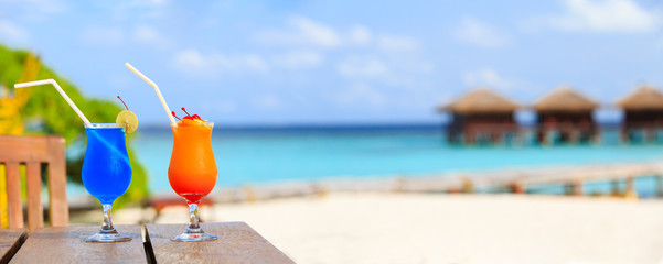 Two cocktails on luxury beach resort, wide panorama